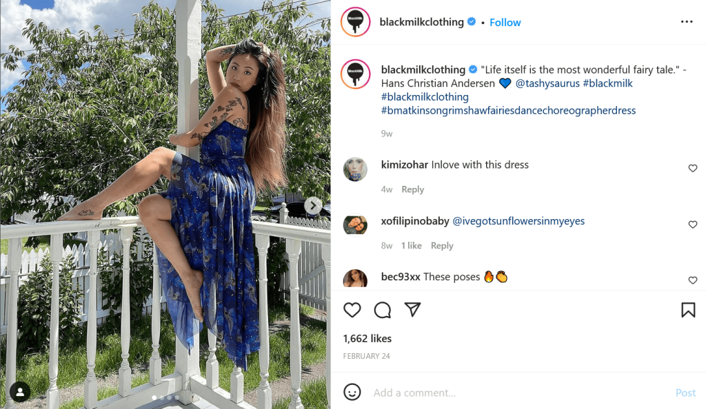 A woman sits on a ledge while she flaunts her blue dress