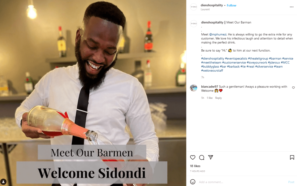 A man is happily pouring a bottle of wine in a glass