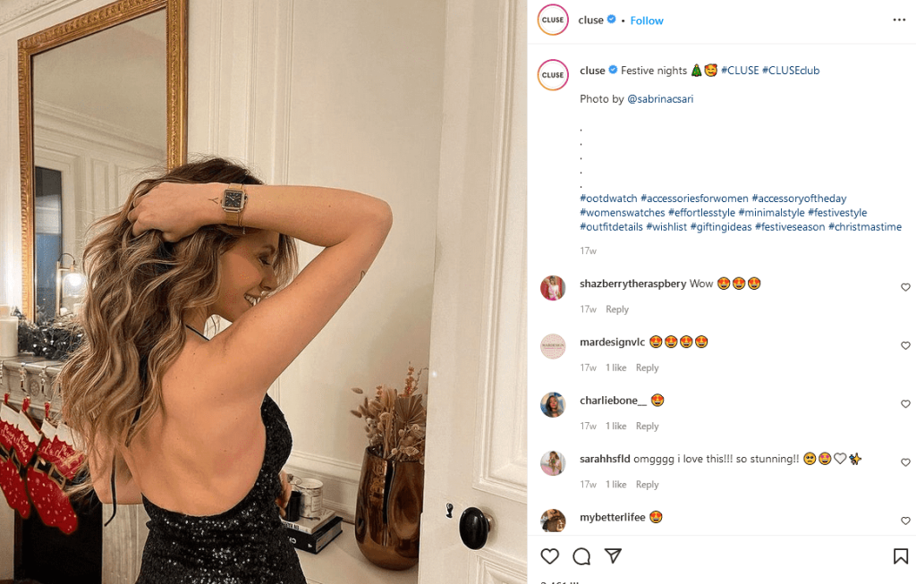 A woman in a black dress shows off her new watch