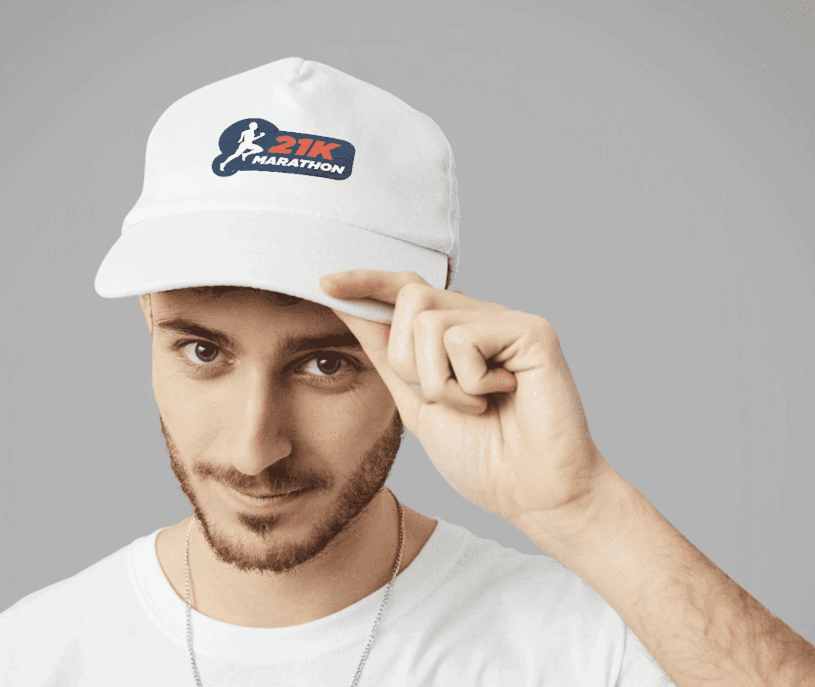 Man tips his white promotional ball cap with blue and crimson marathon logo.