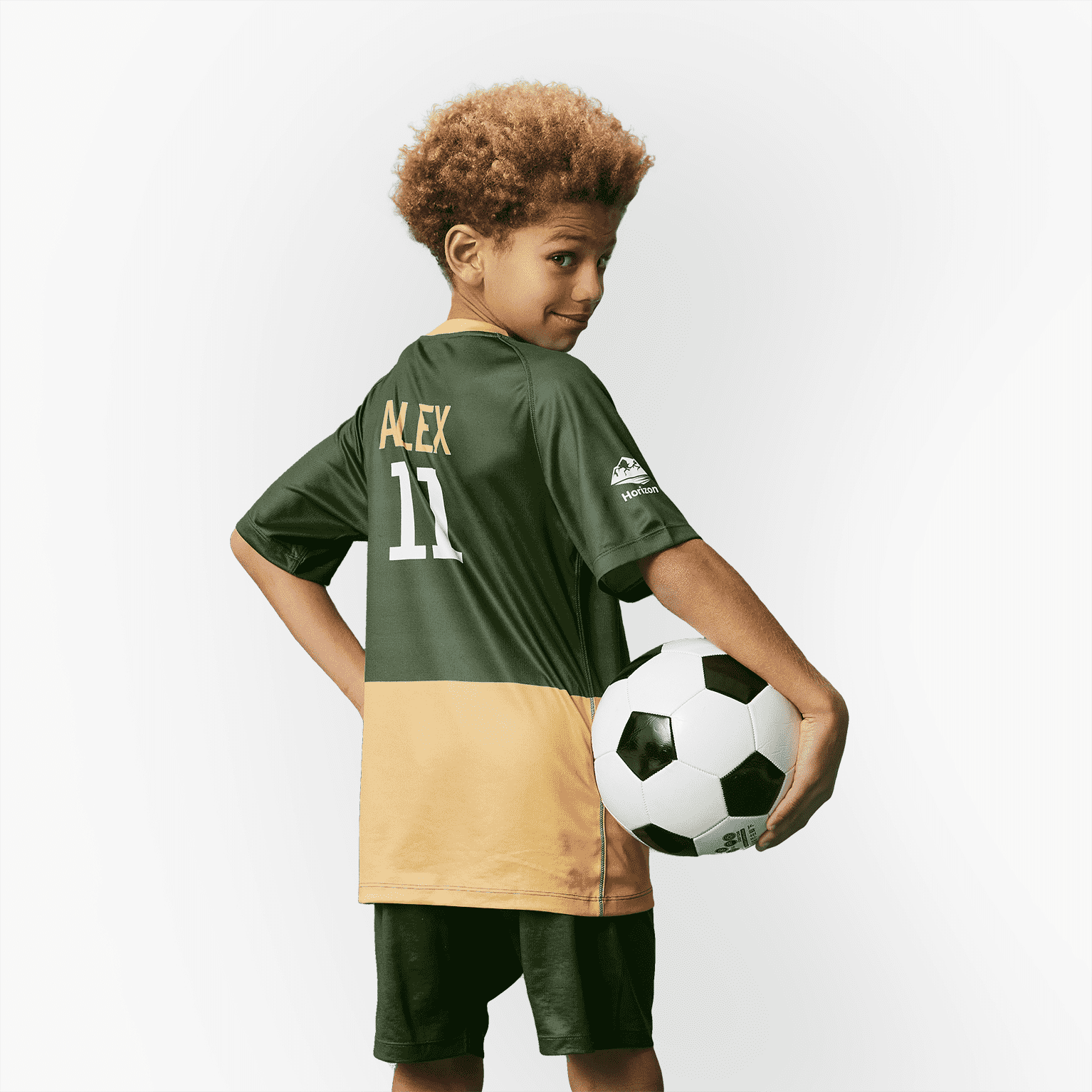 child wearing sports top and holding football