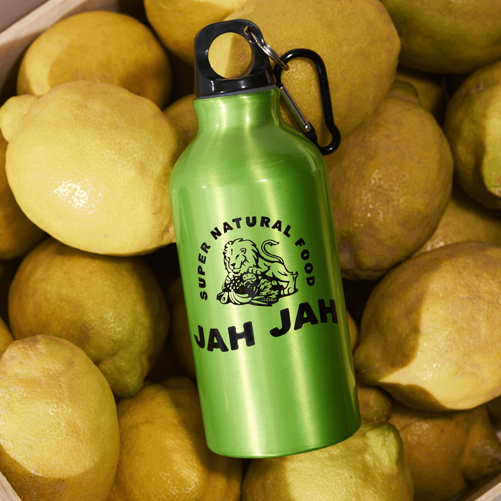 Jah Jah green reusable bottle placed on top bunch of lemons