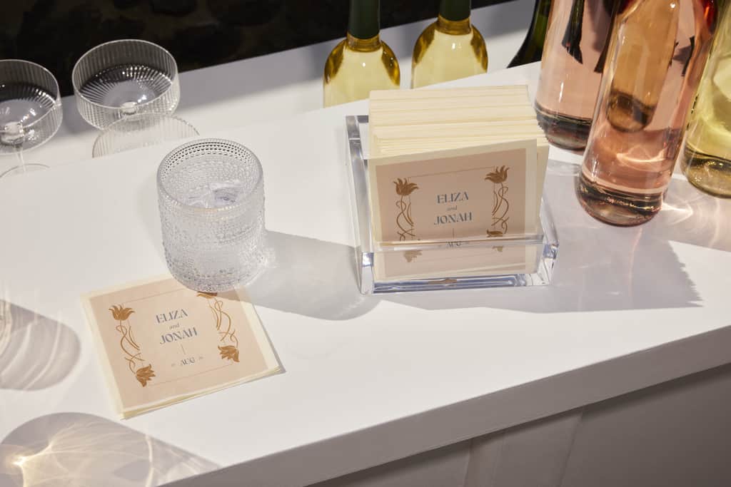 a table with customized wedding napkins and cocktail glasses