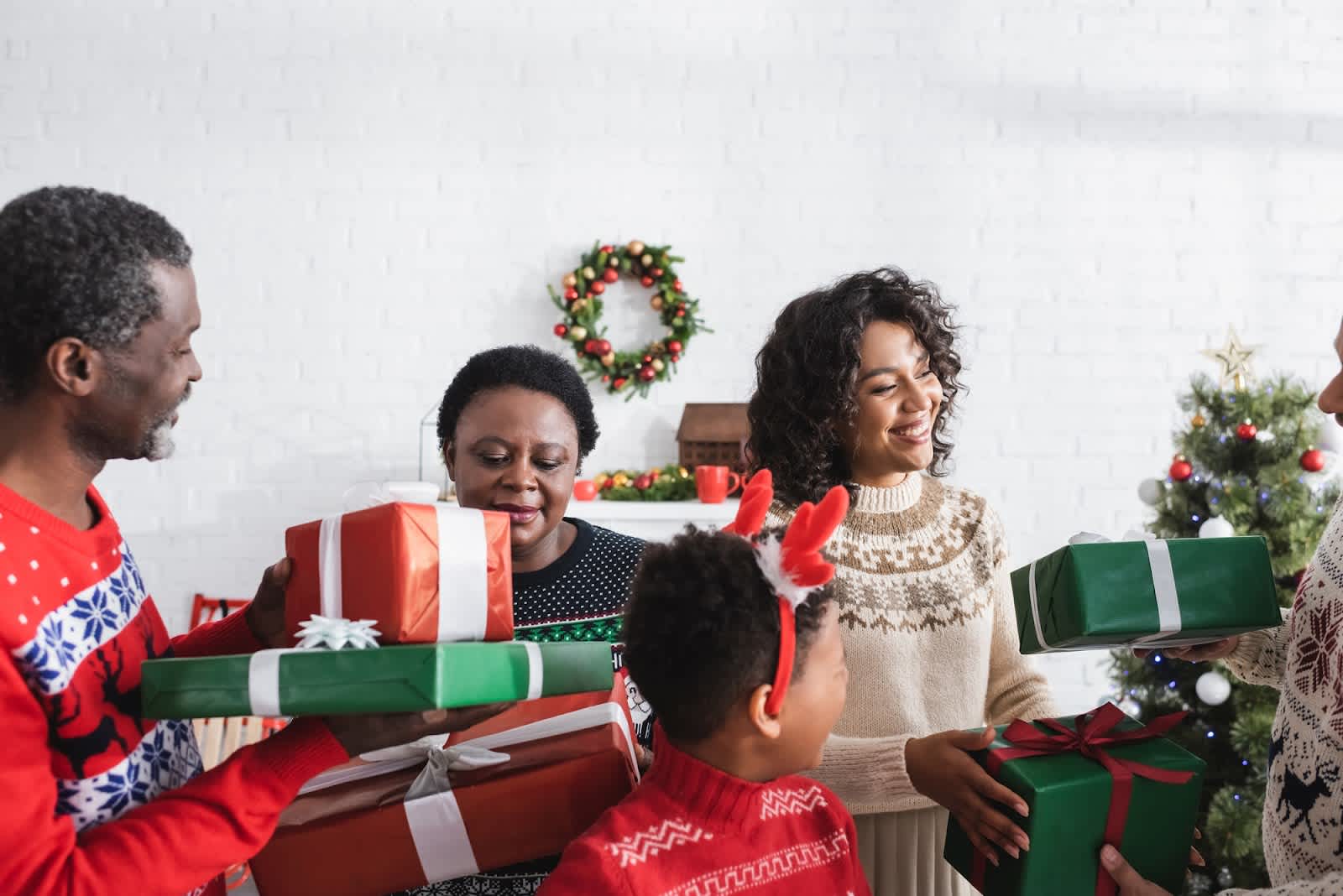 A multi-generational family exchanging gifts and Christmas messages at a Christmas party