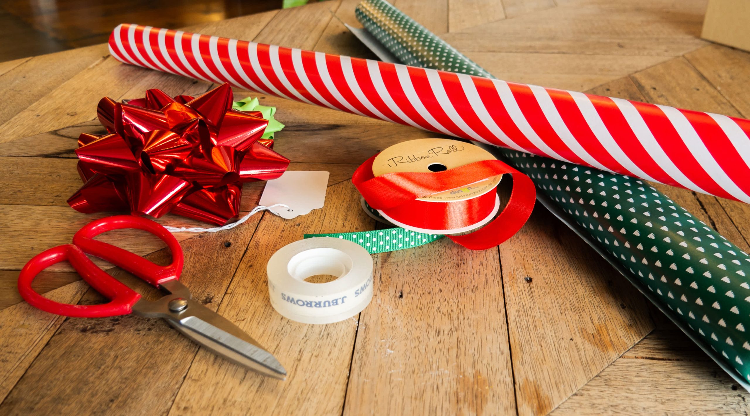 Wrapping paper, ribbon, tape and scissors are the essential tools for wrapping all types of gifts