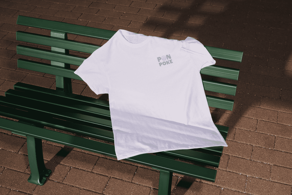T-shirt with a logo on the left chest resting on a bench