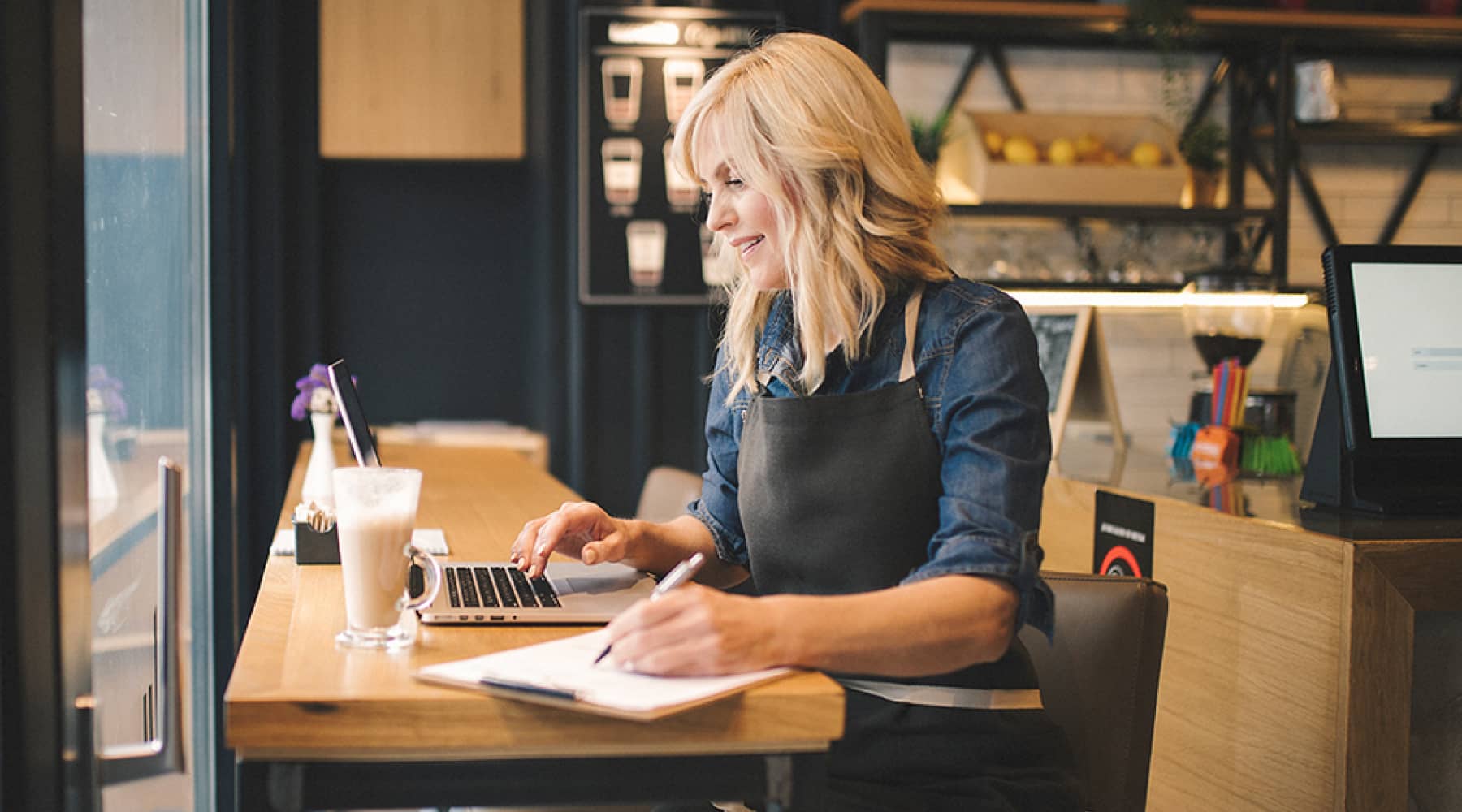 A person sitting at a cafe working on their laptop and business plan