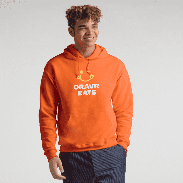 Man wearing orange hoodie with small food business logo