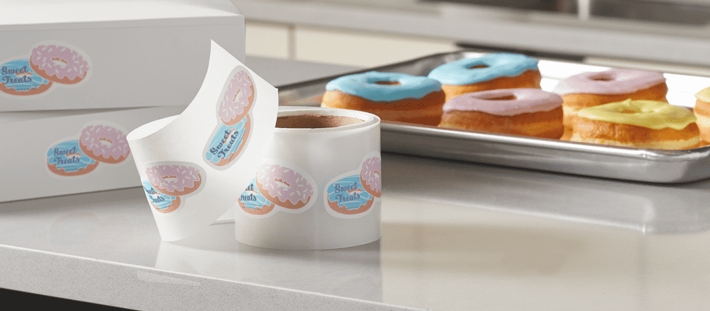 Donuts in a bakery with matching promotional stickers.