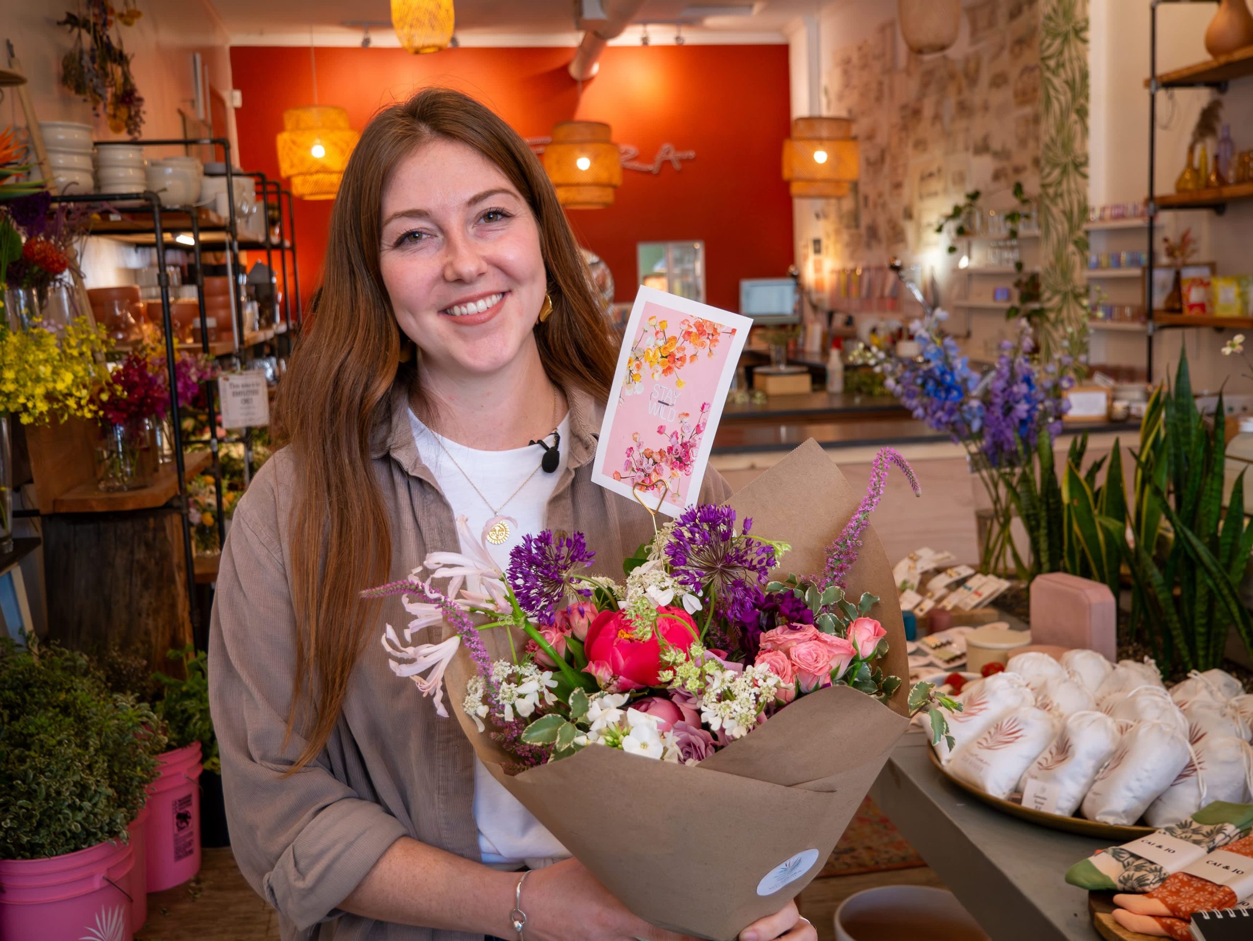 Owner of WildFlora holding a bouquet of flowers in her shop
