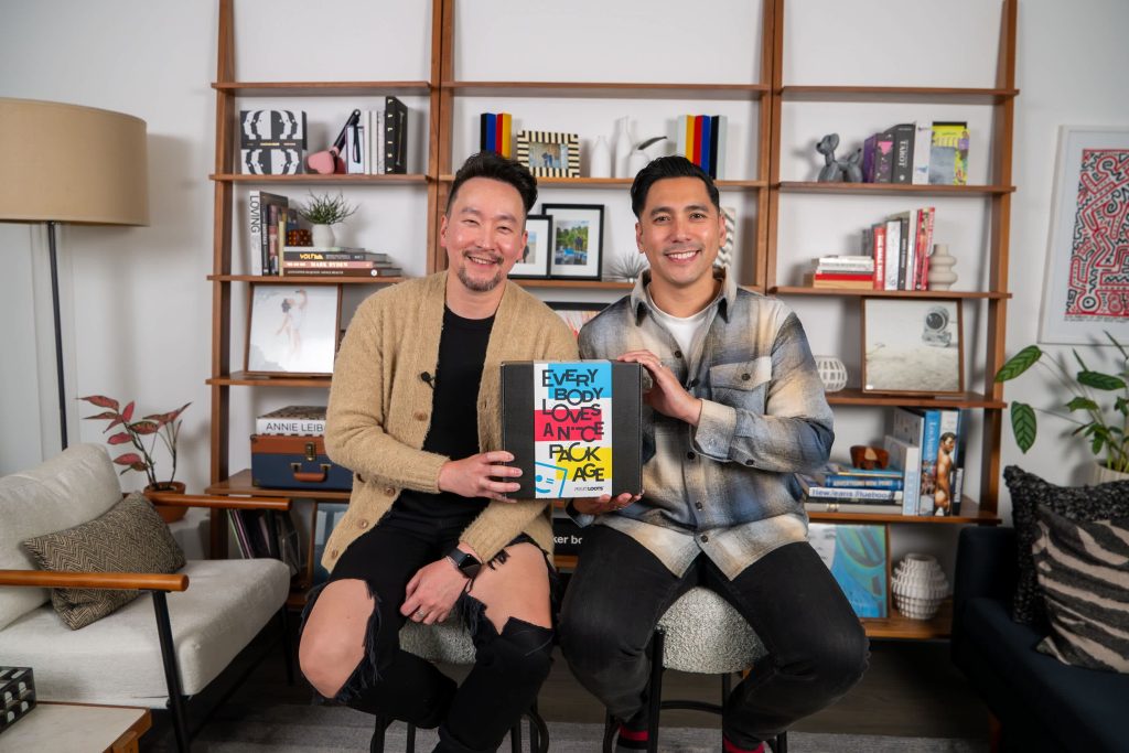 Two men holding box.