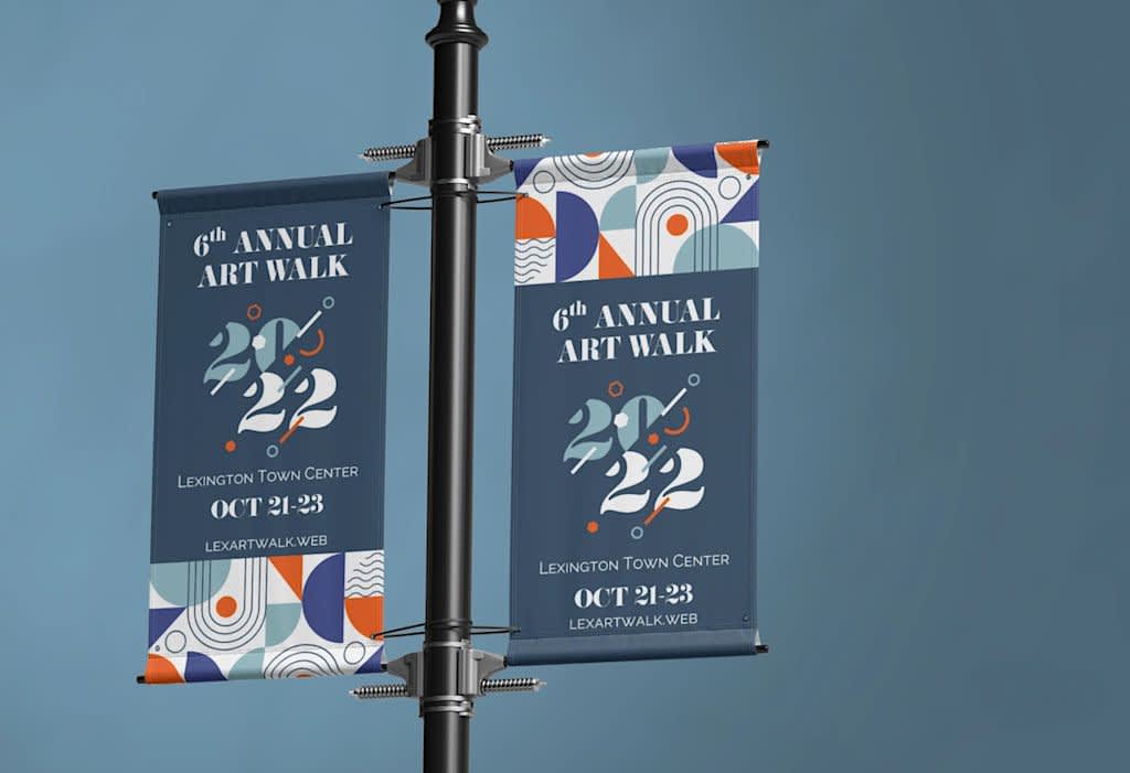 Pole banners advertising an annual art walk attached to both sides of a street light