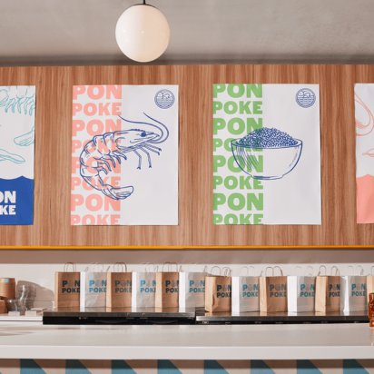 Colorful store counter with branded poster fonts, coordinated menus, paper bags, and logo stickers.