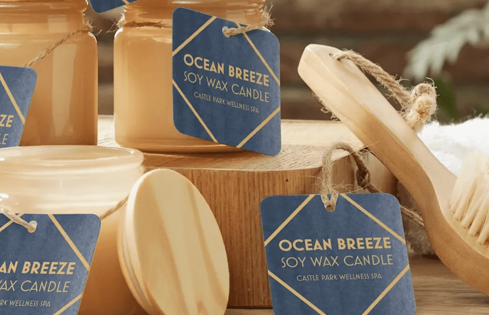 A kraft paper hang tag labeled 'Ocean Breeze' attached to a candle with twine.