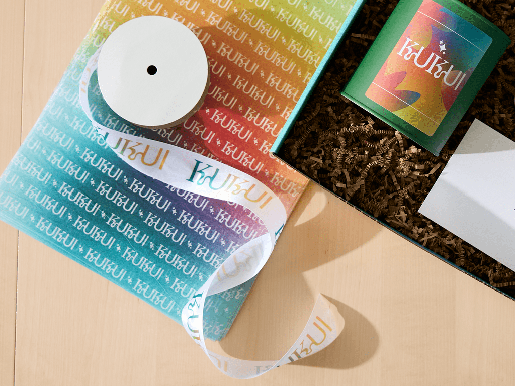 Brand packaging with branded tissue paper, ribbons and textured inserts.