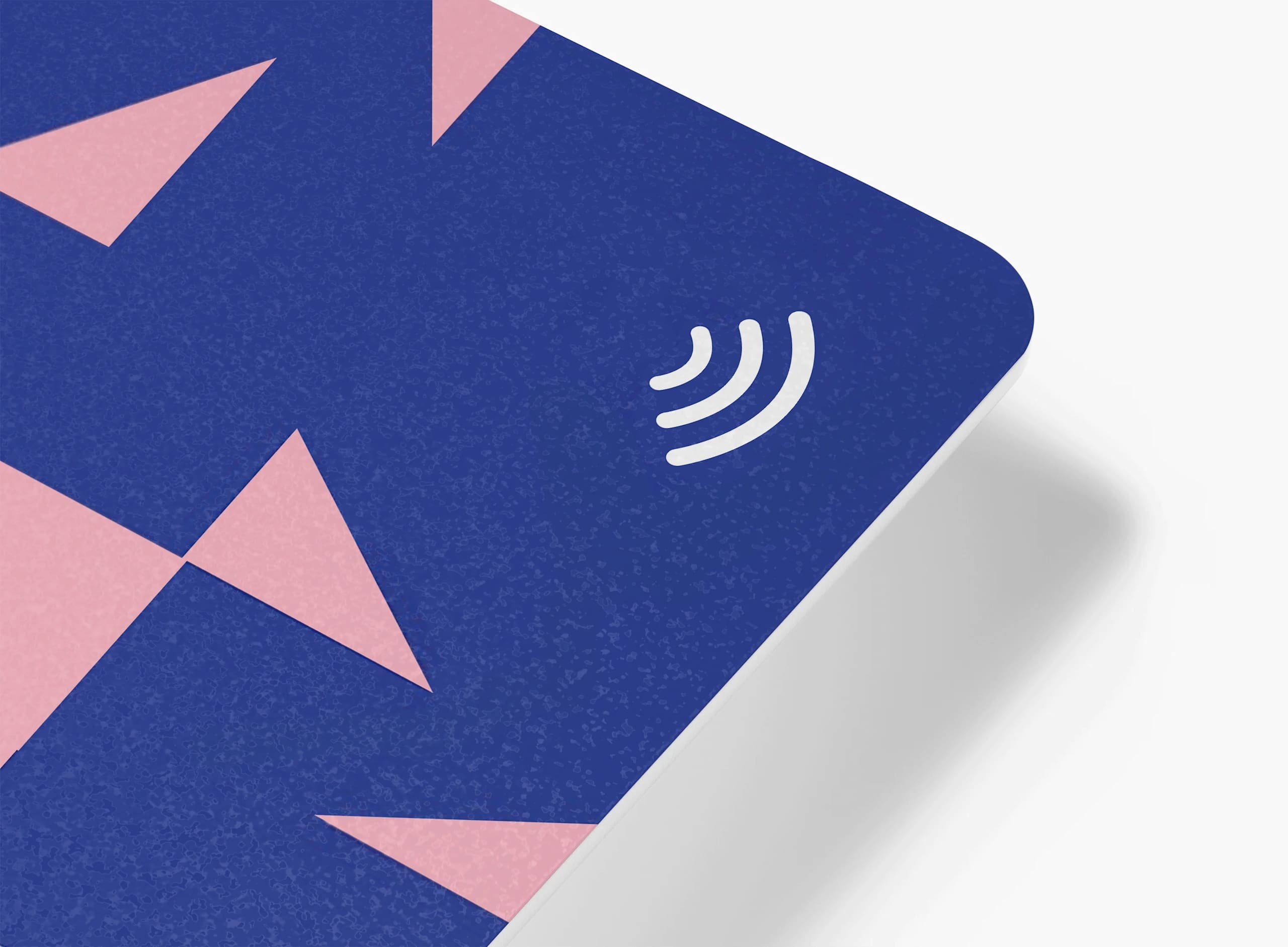 A zoomed in corner of a blue and pink business card to showcase the NFC symbol in white, in finer detail