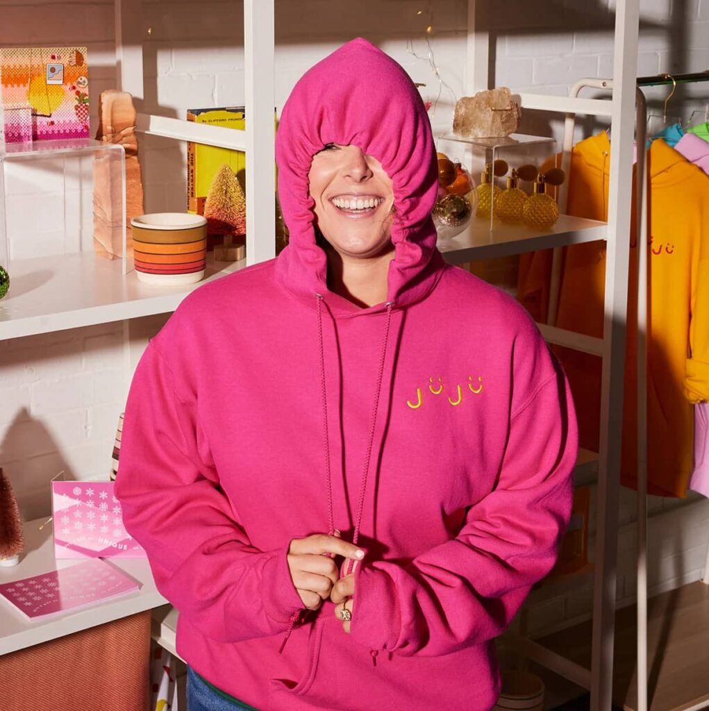An image of a woman wearing a branded hoodie