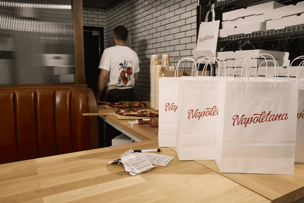 White paper bags with a red logo for a restaurant&rsquo;s packaging design