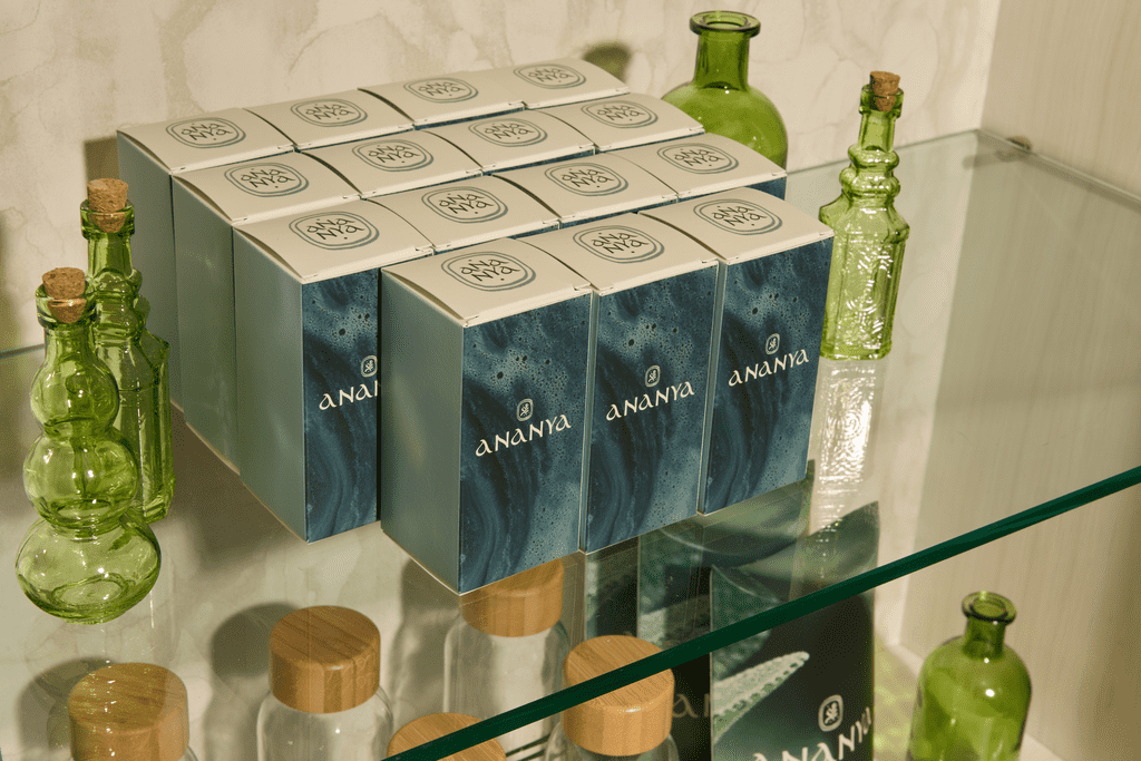 Selection of identical rectangular product packages on shelf with abstract design and logo on front panels and black and white logo on top panel