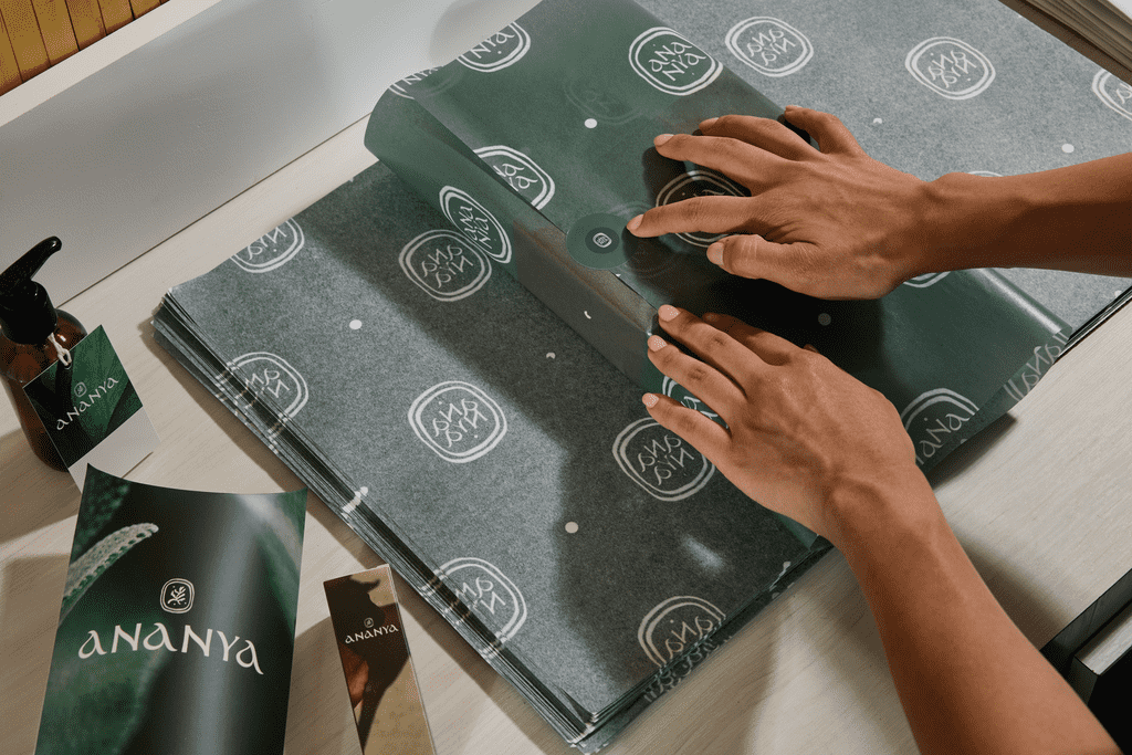 Small business owner wrapping custom tissue over a product