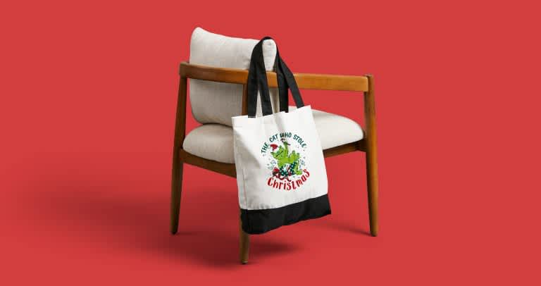 Custom holiday tote hanging off a chair.