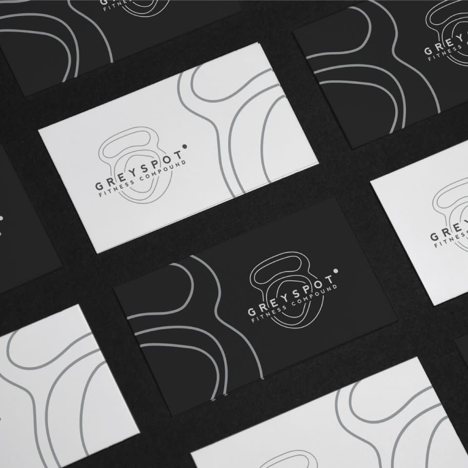 Black and white inverse business card designs with line drawn image of kettle bell and text “Greyspot Fitness Compound”.