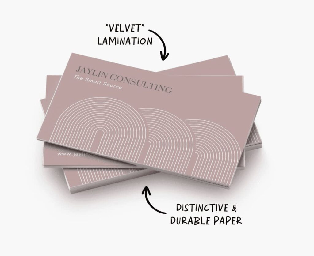 Taupe business card with simple white line graphic and contact info with arrows describing the velvet lamination texture.
