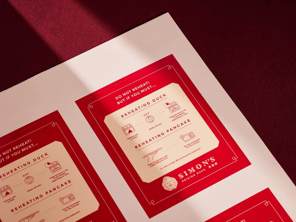 Red and cream Simon's Peking Duck instruction cards with illustrated steps for reheating duck and pancakes.