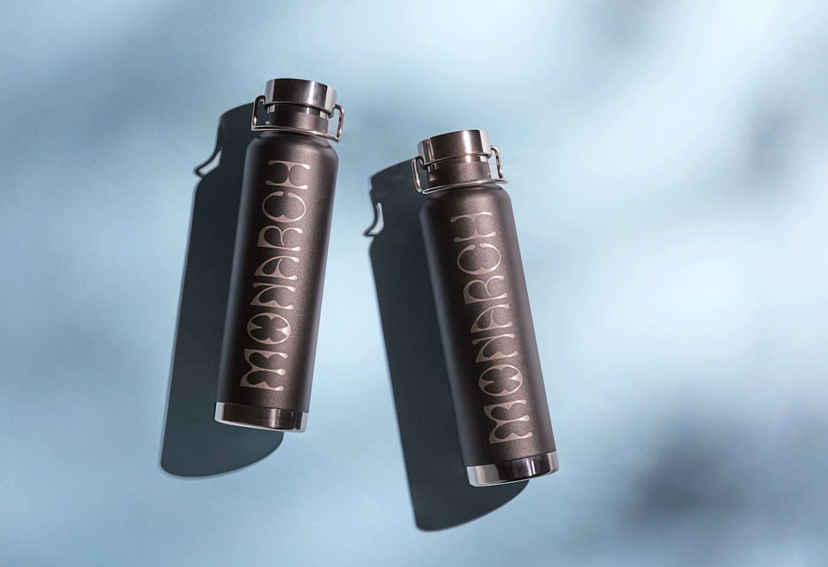 Two dark gray water bottles featuring a logo that says “Monarch”