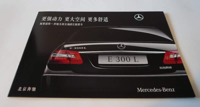The rear of a black Mercedes-Benz on a black backdrop